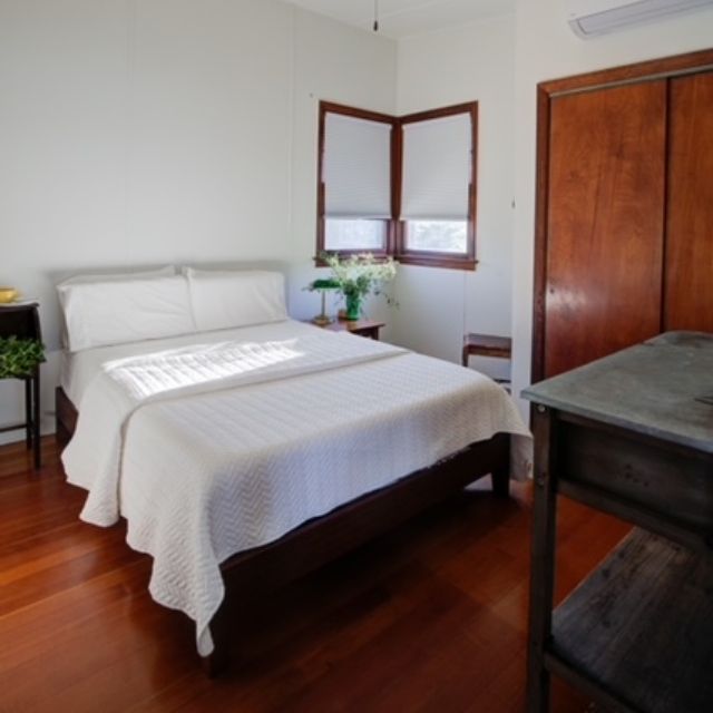 A bedroom with a large bed and two windows