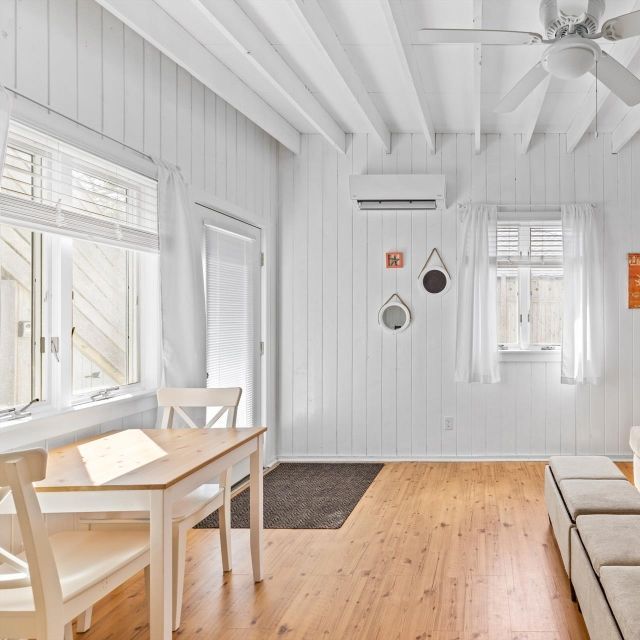 A living room with a table and chairs and a ceiling fan
