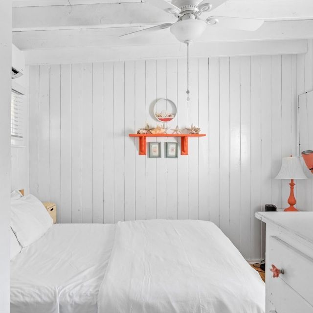 A bedroom with a bed and a ceiling fan