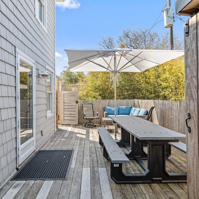 A wooden deck with a picnic table and umbrella