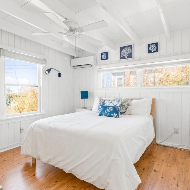A bedroom with a bed and a ceiling fan