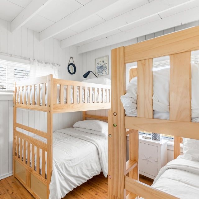 A bedroom with two bunk beds and a nightstand