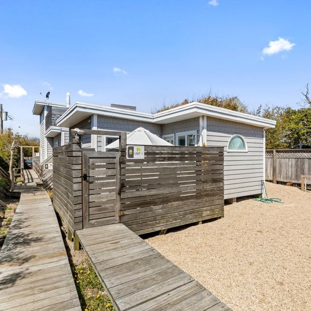 A small house with a wooden walkway leading to it
