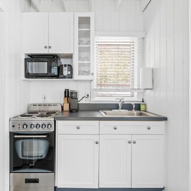 A small kitchen with white cabinets and stainless steel appliances