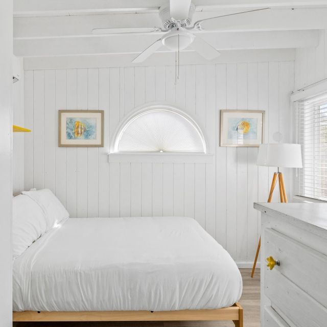 A bedroom with a bed and a ceiling fan