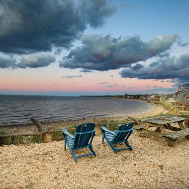 A circle of chairs and a picnic table on a beach