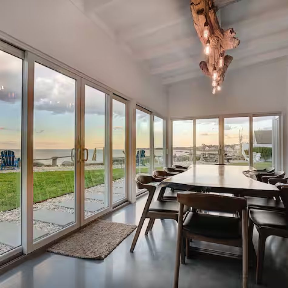 A dining room with a table and chairs and a chandelier hanging from the ceiling.