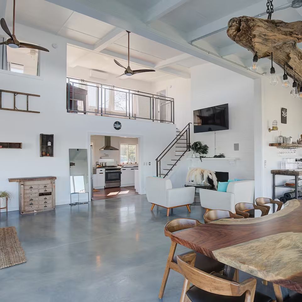 A living room with a table and chairs and a staircase