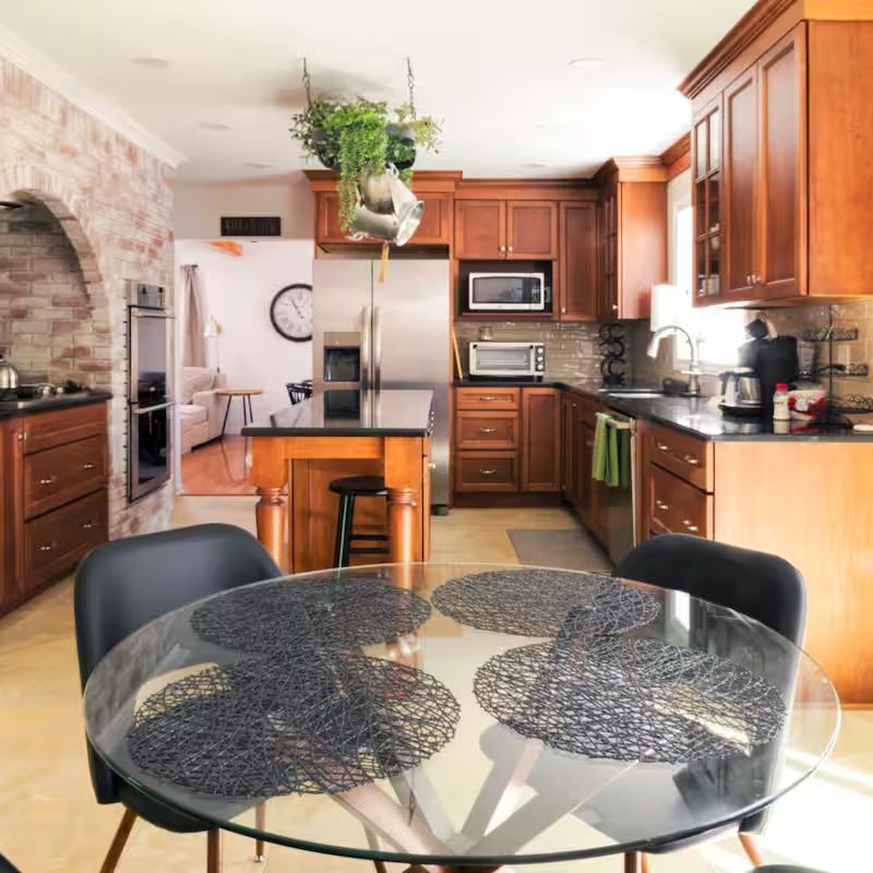 A kitchen with a round glass table and chairs