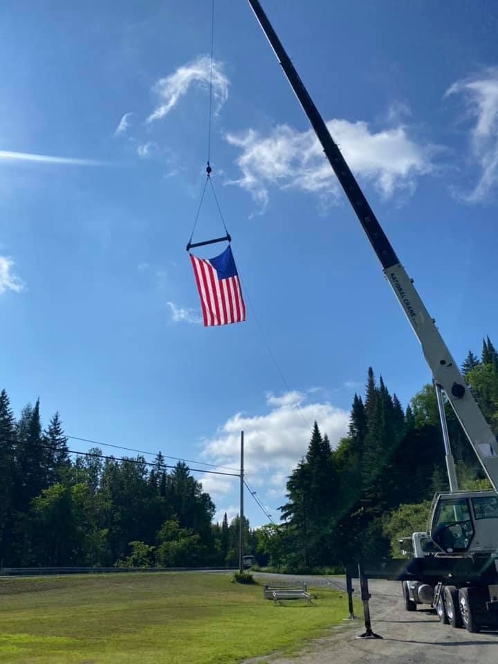 A crane flies an American flag on the Mayo Crane Rental lot