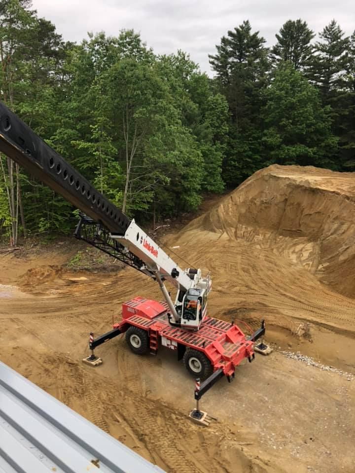 A crane truck sits ready on a newly excavated lot