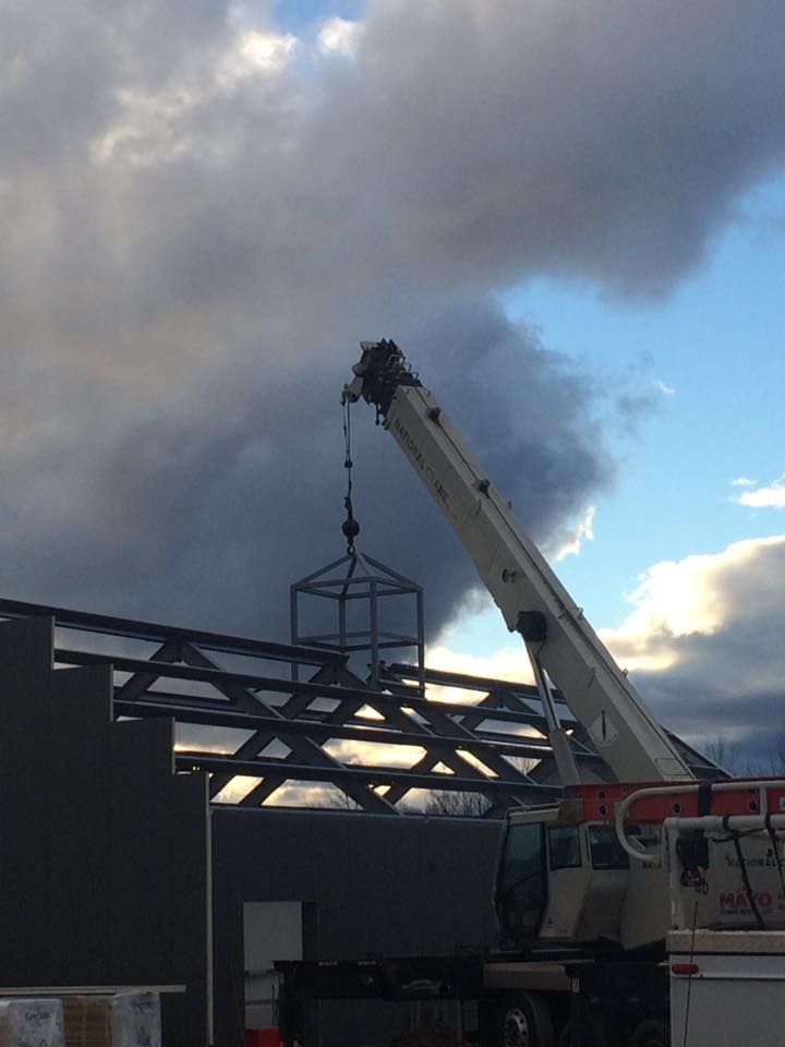 A crane lifts part of a roof structure into place in Vermont