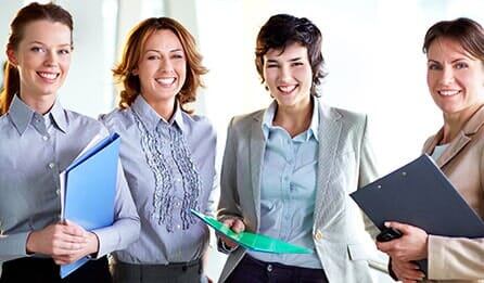 Stock image of four smiling professional women holding folders - Orlando, Florida - Law Office of Amber Johnson