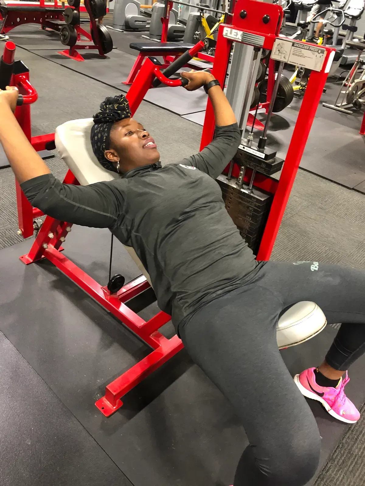 A woman is using a machine in a gym.