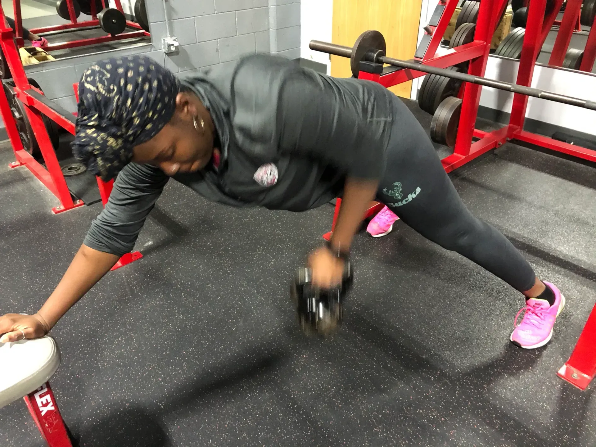 A woman is doing push ups on a bench in a gym.