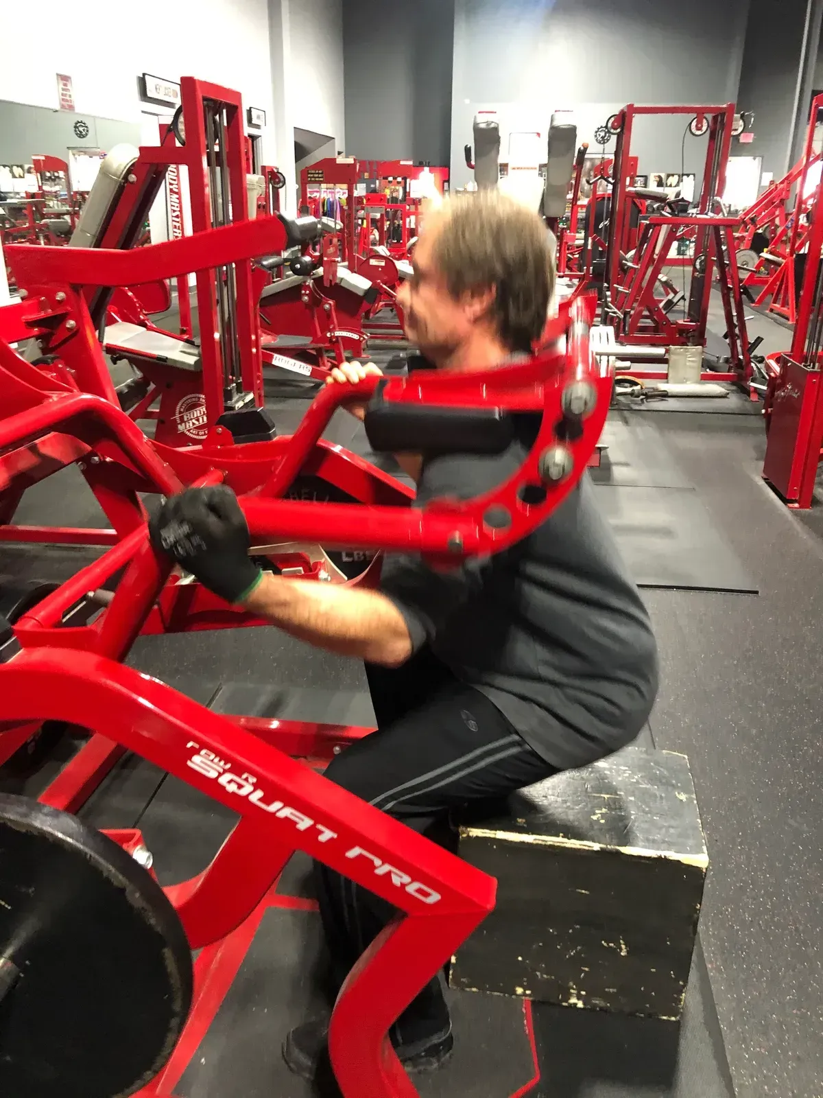 A man is using a machine in a gym that says biolift on it