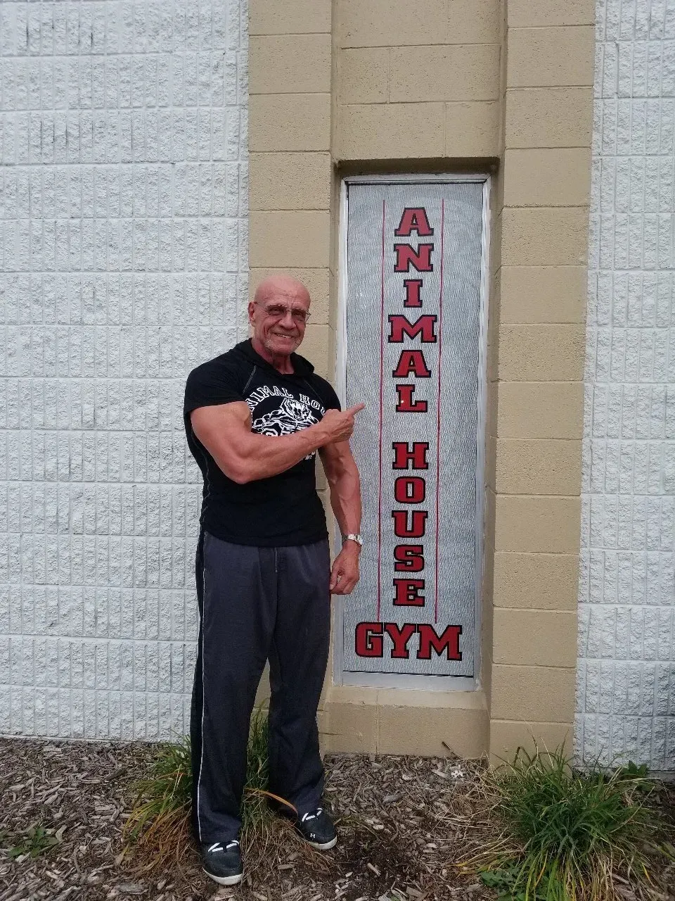 A man standing in front of a sign that says animal house gym