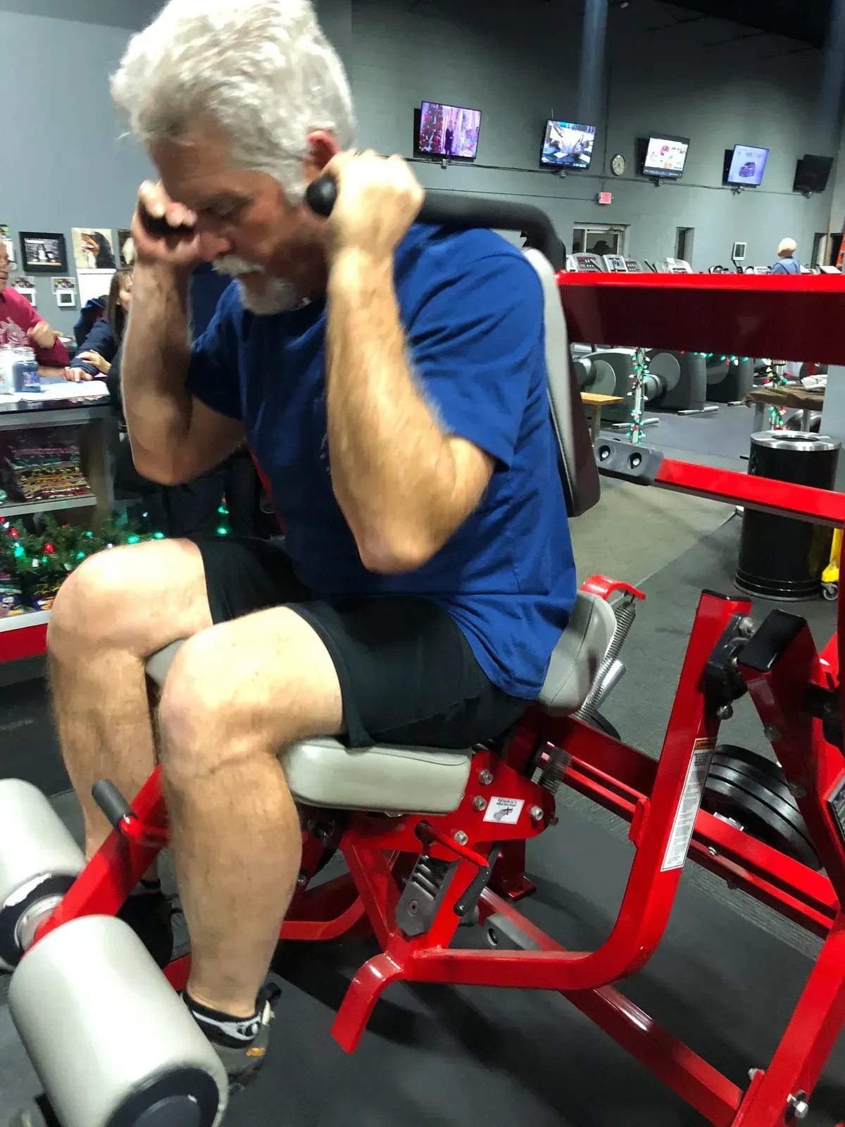 A man is doing exercises on a machine in a gym