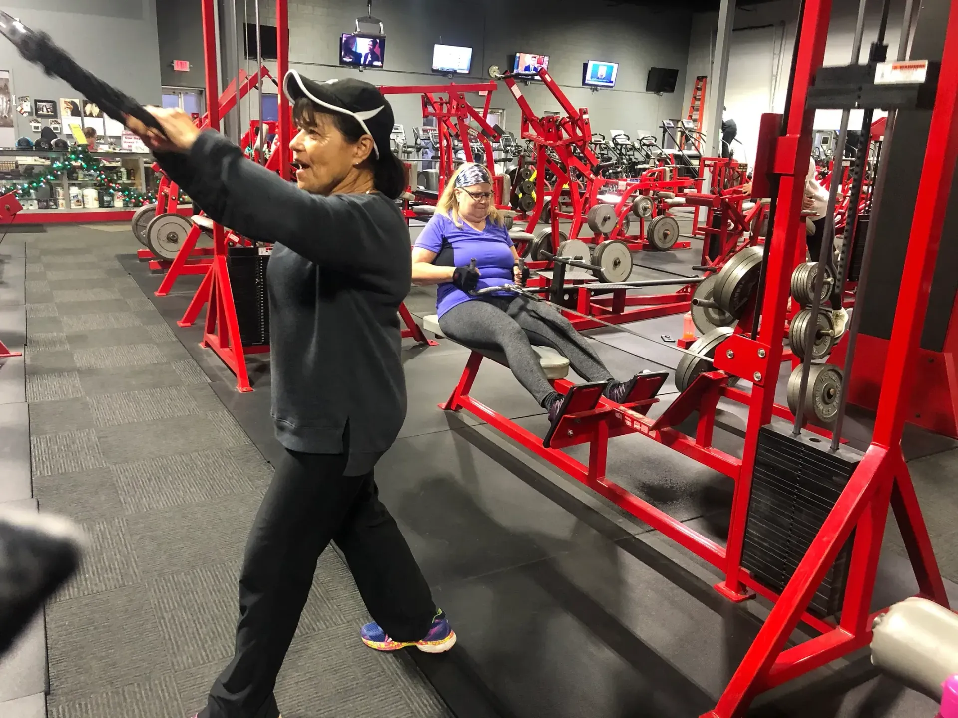A woman is using a machine in a gym.