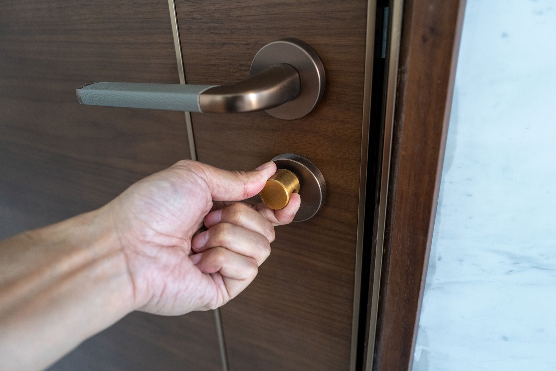 A person is opening a door with their hand.