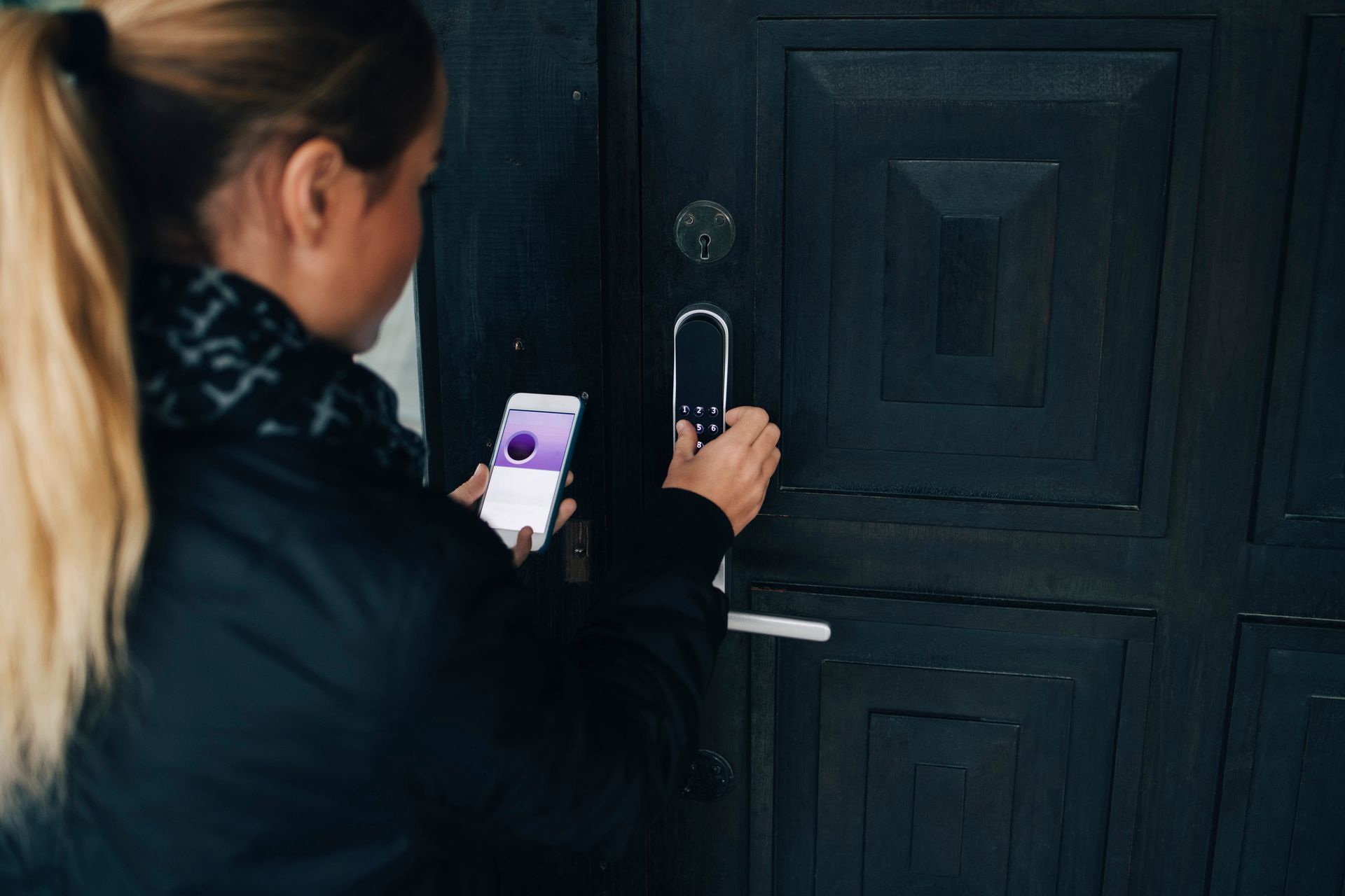 A woman is opening a smart lock.