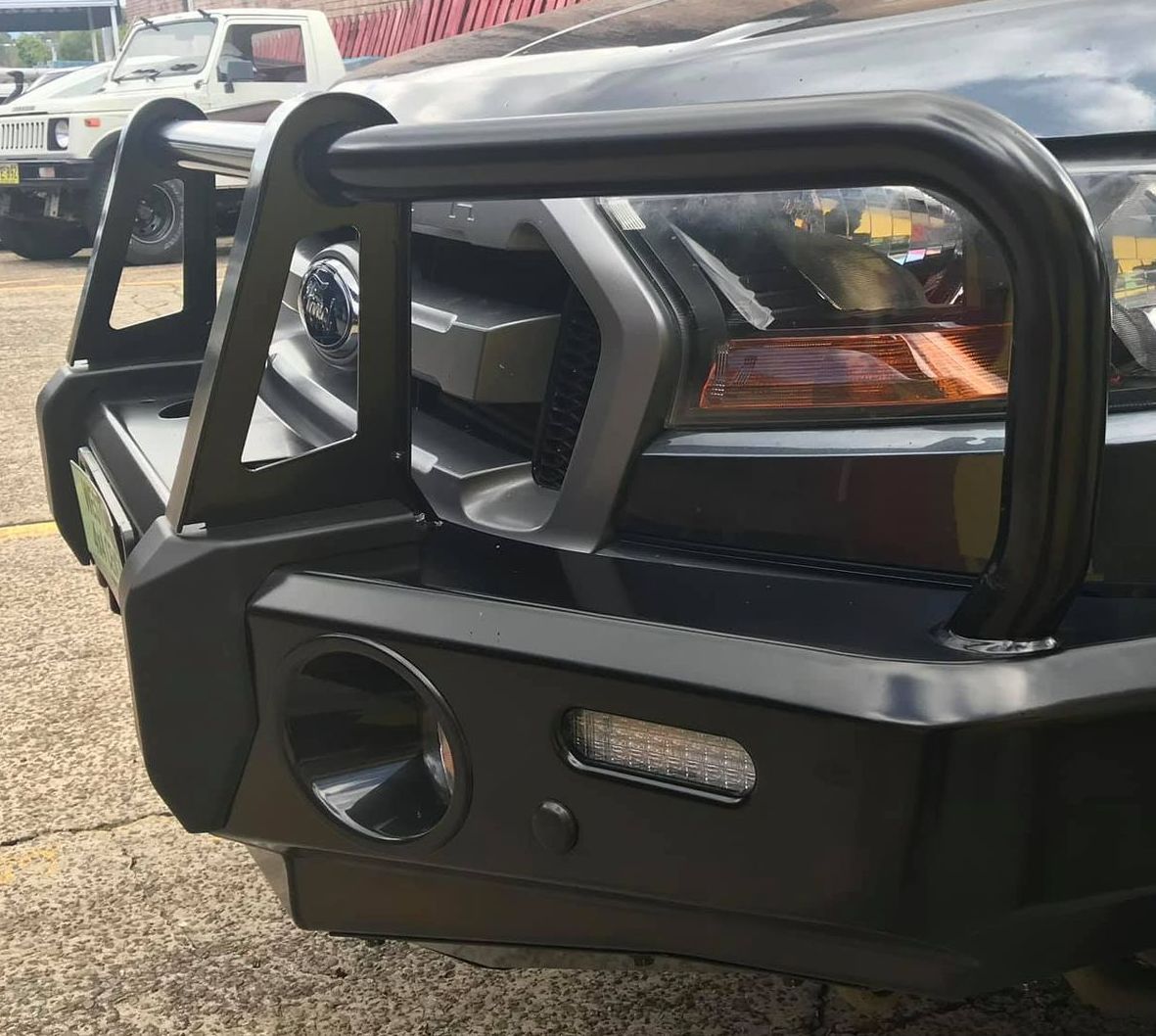 A Black Car With a Bumper on It is Parked on the Side of the Road — Westlakes 4x4 Centre in Newcastle, NSW