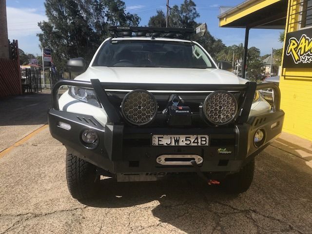 A White Truck With a Black Bumper is Parked in Front of a Yellow Building — Westlakes 4x4 Centre in Maitland, NSW