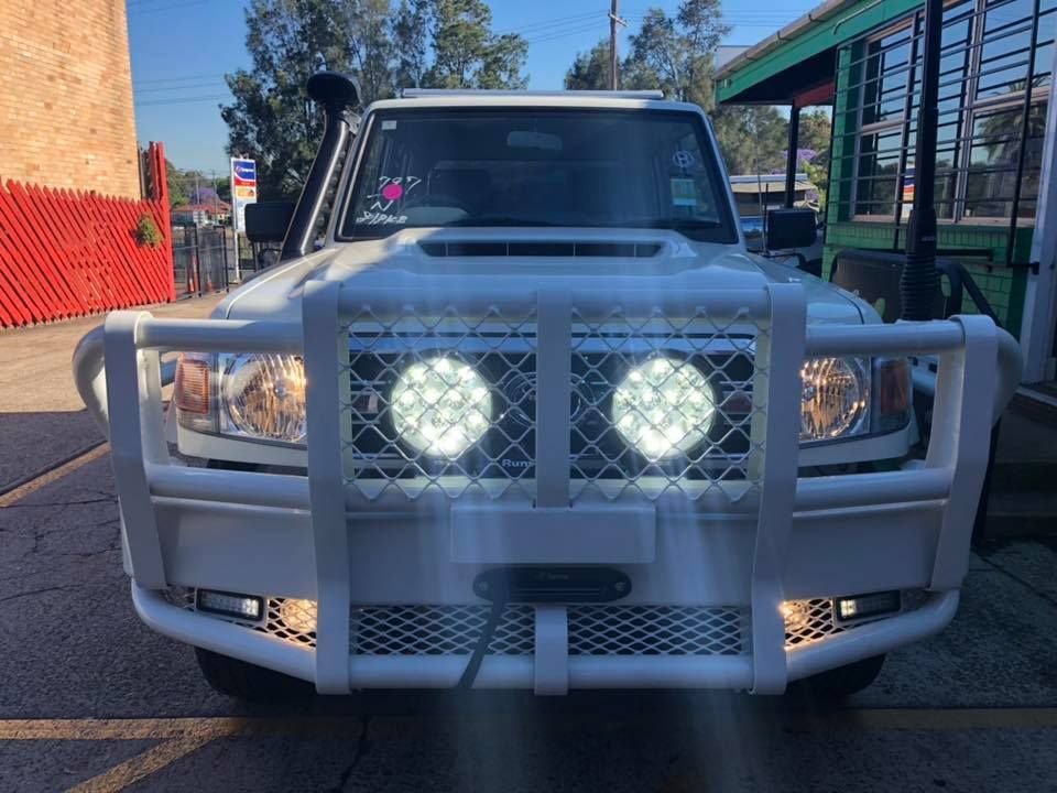 A White Truck With Lights on the Front is Parked in a Parking Lot — Westlakes 4x4 Centre in Maitland, NSW