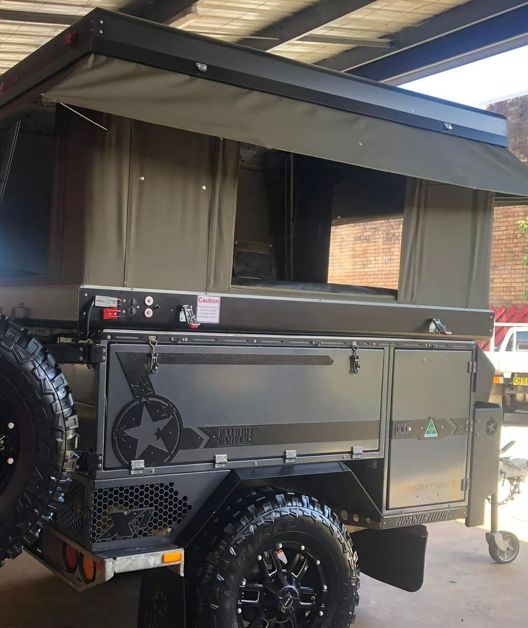 A Trailer With a Tent on Top is Parked Under a Roof — Westlakes 4x4 Centre in Singleton, NSW