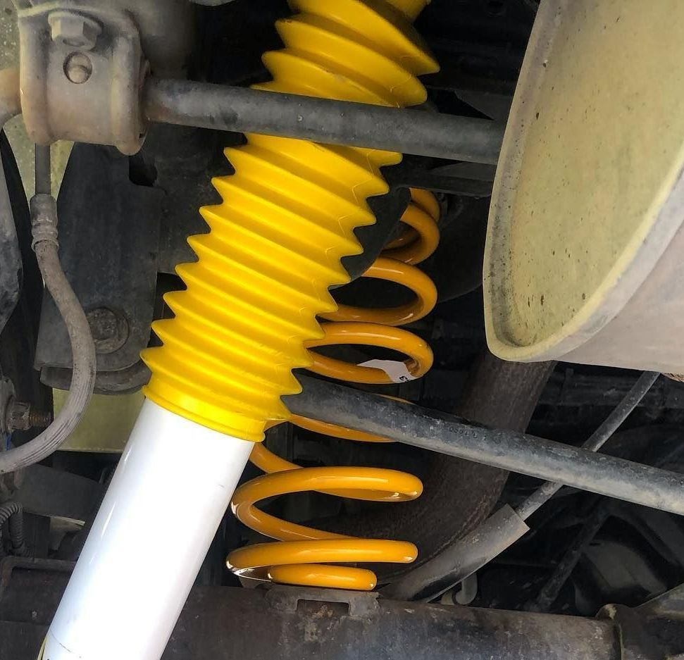 A Close Up of a Yellow Shock Absorber on a Car — Westlakes 4x4 Centre in Newcastle, NSW