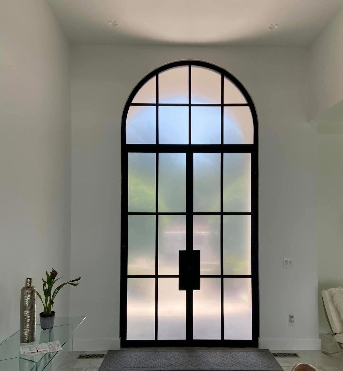 Men installing window film inside a building, using ladders.