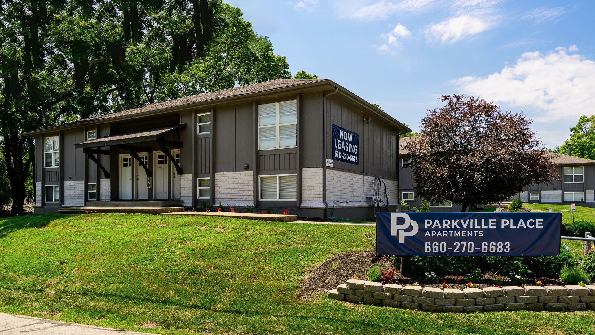A building with a sign in front of it that says parkville place