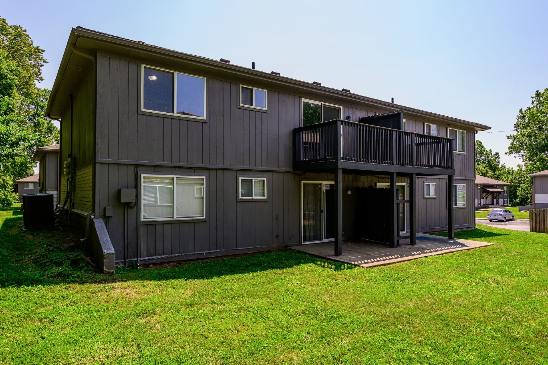 The back of a house with a large lawn in front of it.
