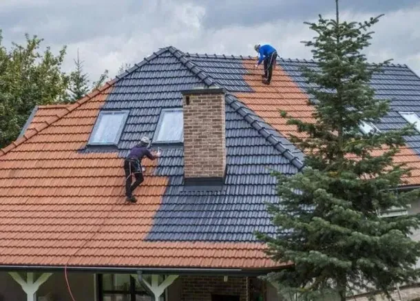 Two men are restoring the roof of the house to it's original state.