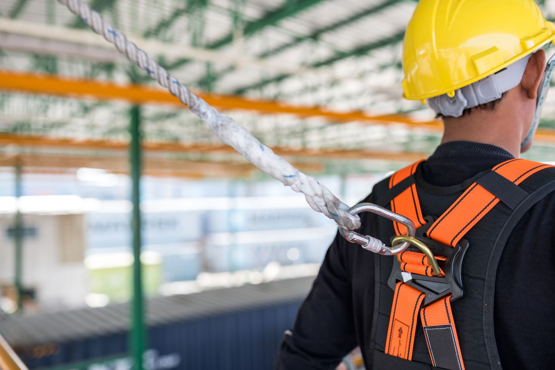 A construction worker wearing a hard hat and safety harness.