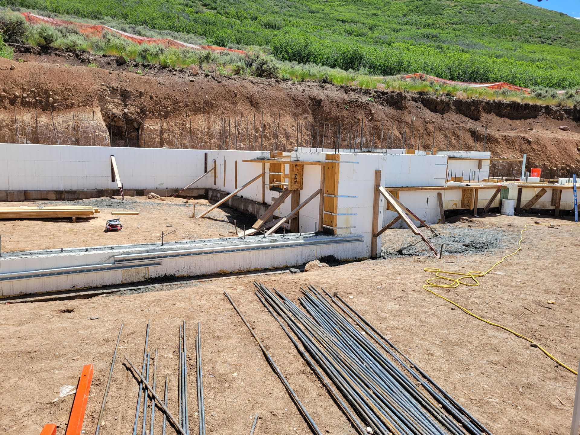 A construction site with a lot of steel bars in the dirt.