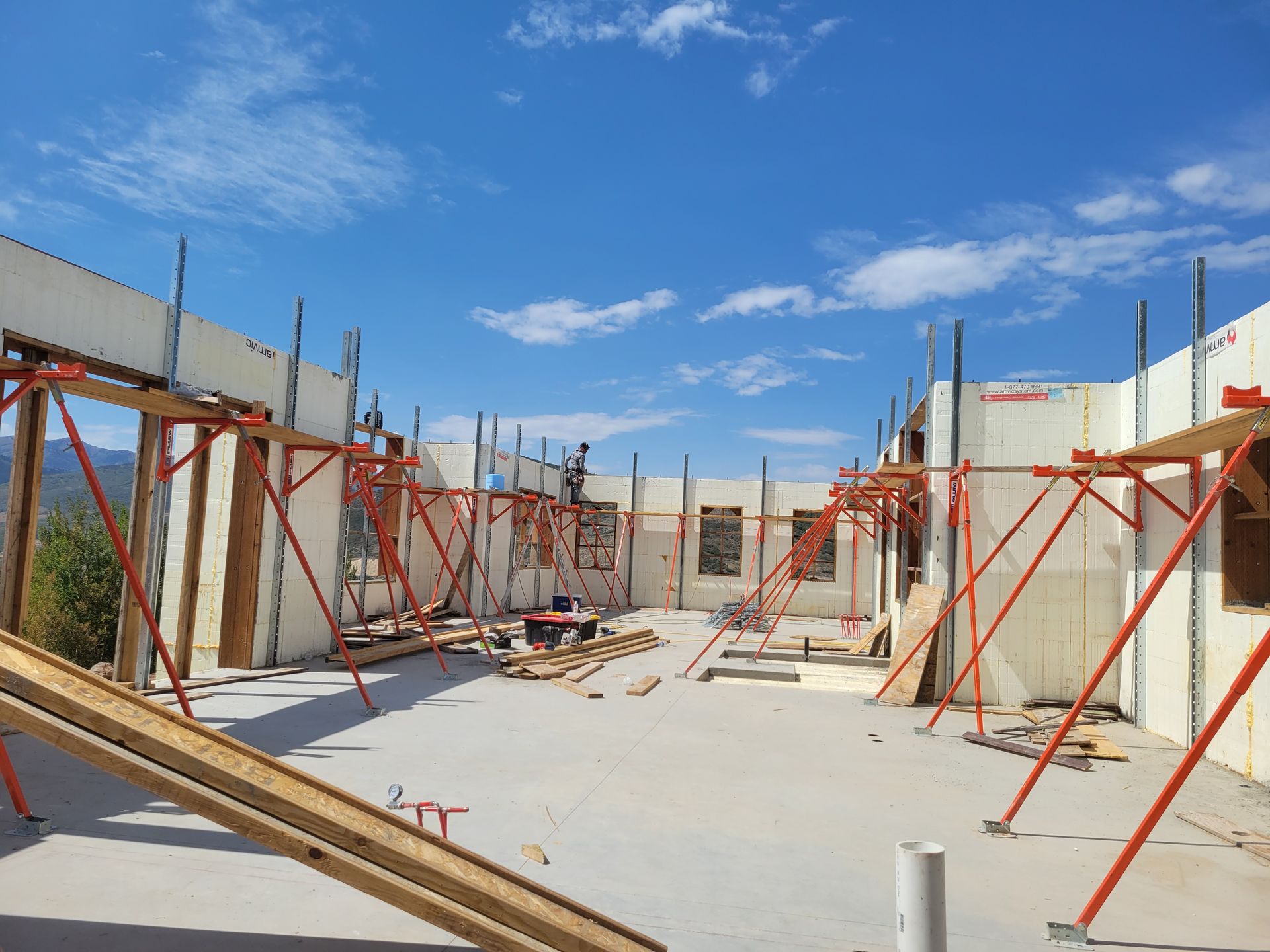 A large building under construction with scaffolding and a blue sky in the background.
