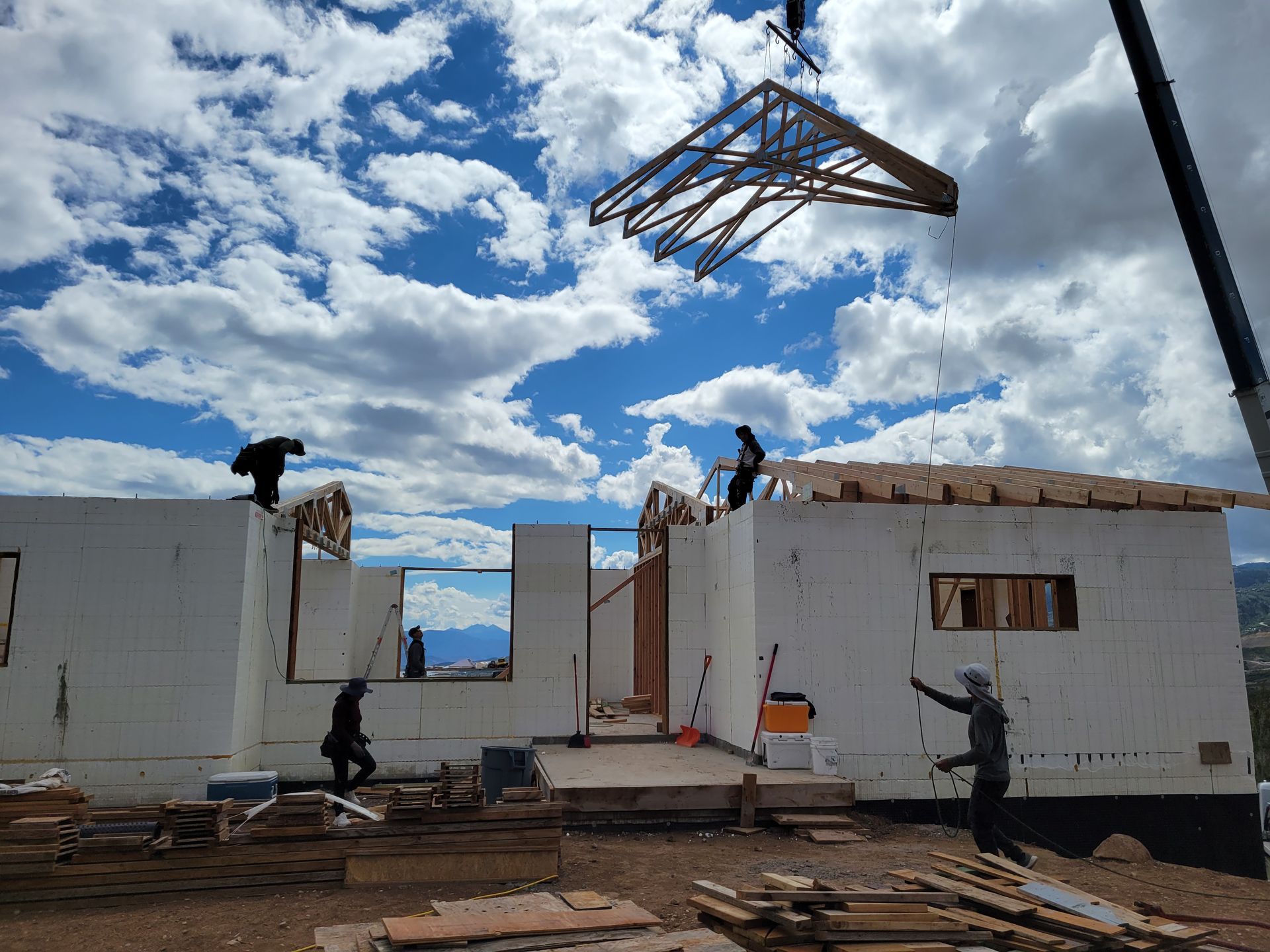 A group of people are working on a house under construction.