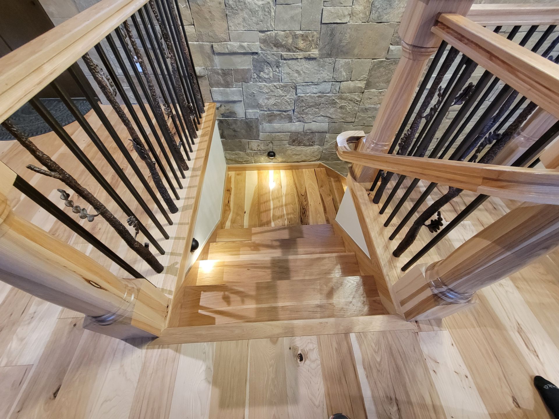 An aerial view of a wooden staircase with black railings