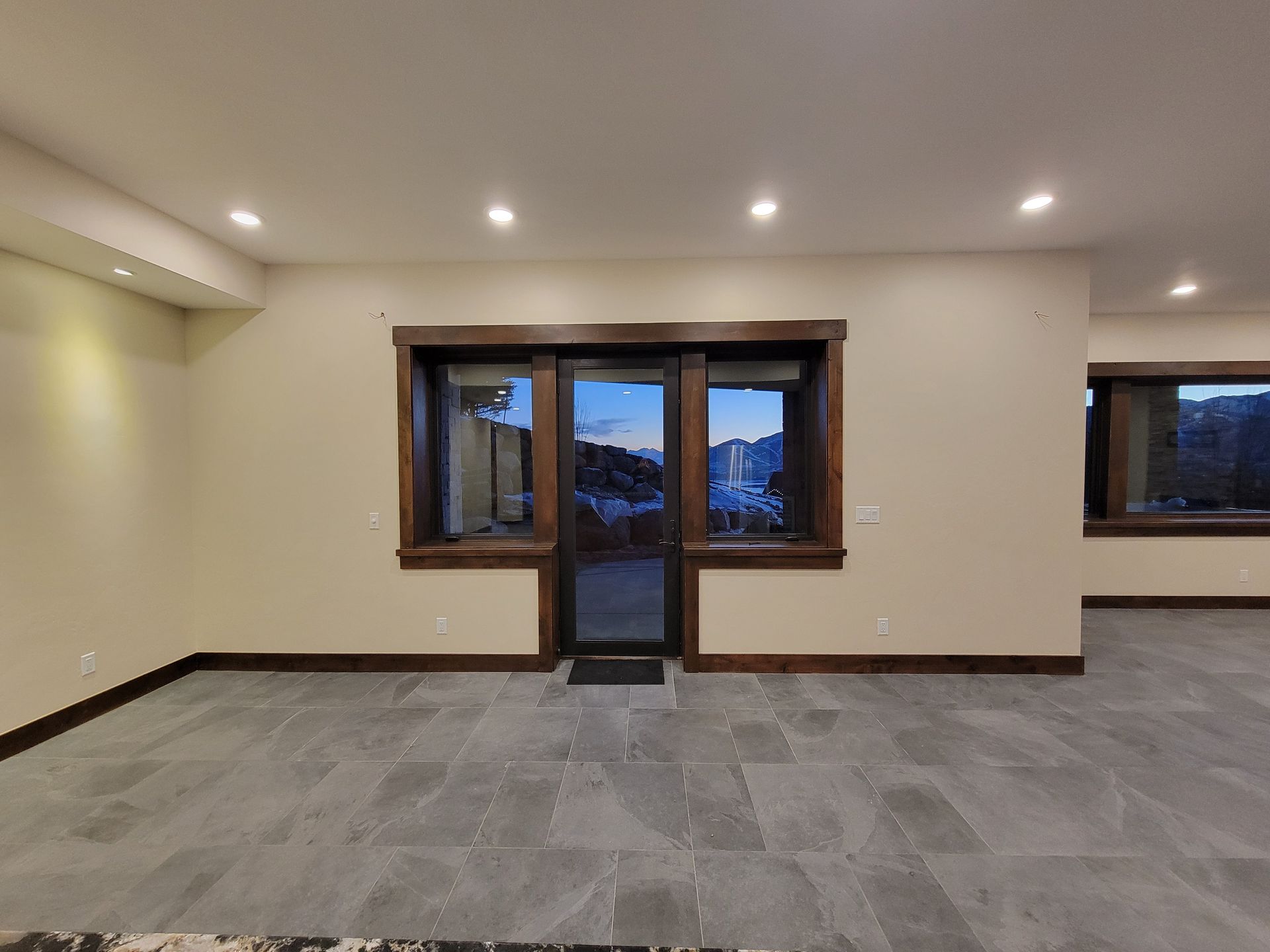 An empty room with a sliding glass door and two windows
