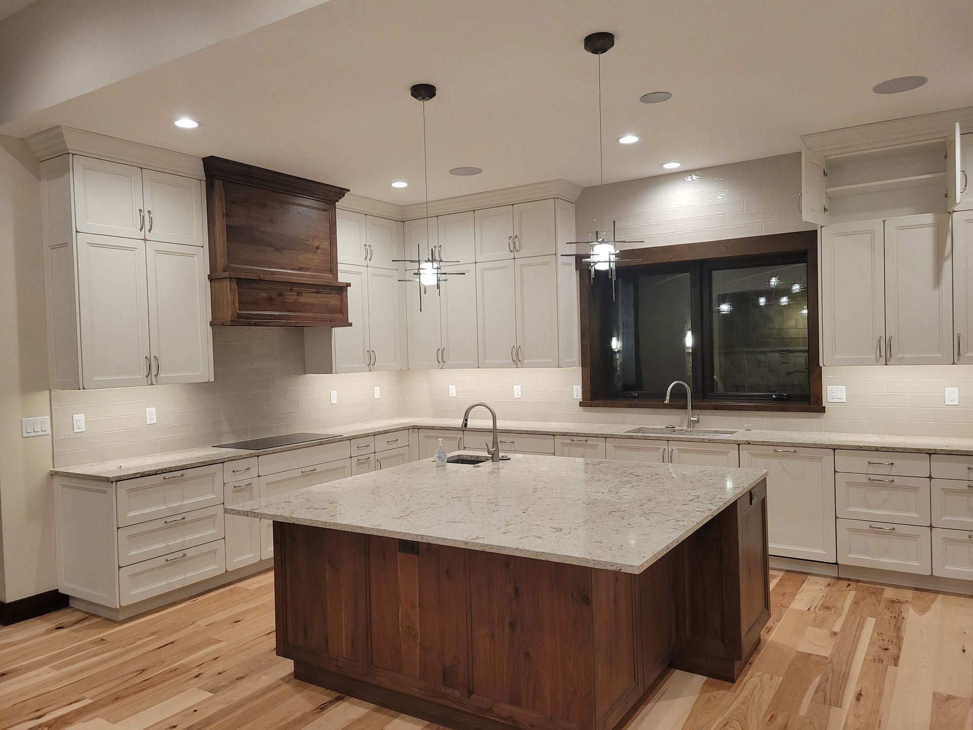 A kitchen with white cabinets and a large island in the middle.