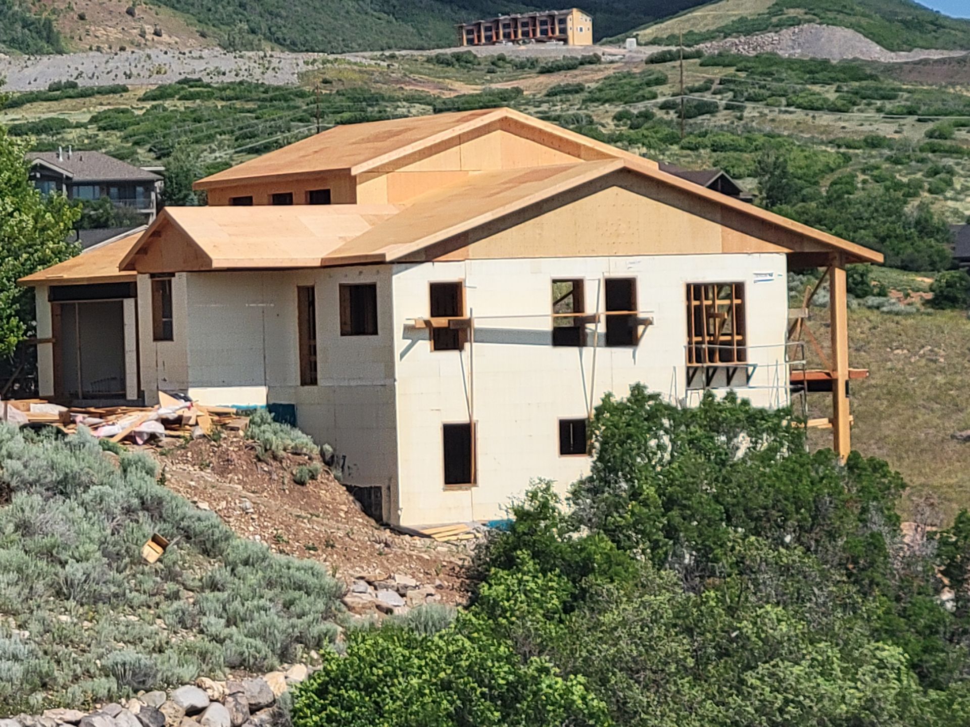 A large house is being built on top of a hill.