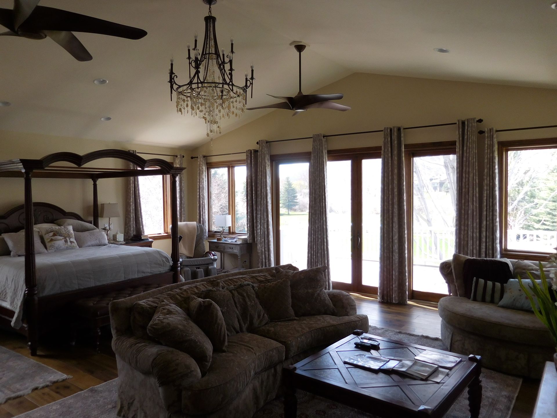 A bedroom with a four poster bed and a couch