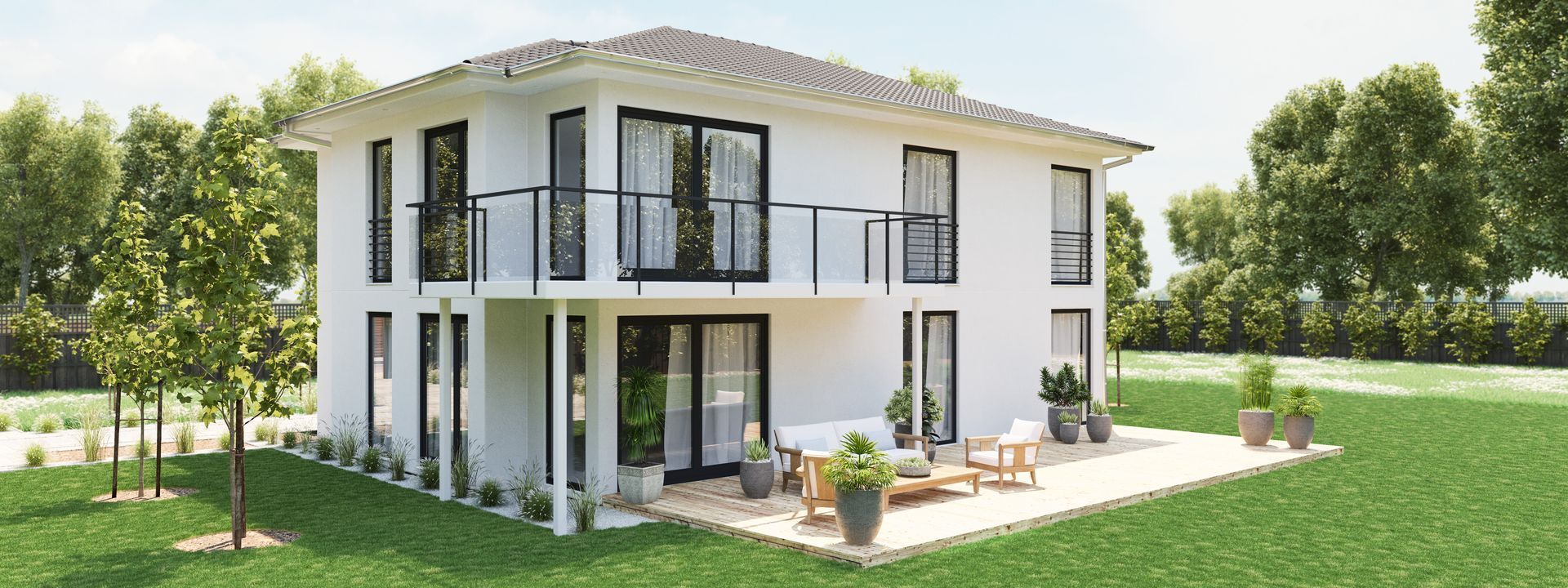 Ein weißes Haus mit einer Terrasse davor steht auf einer üppigen grünen Wiese.