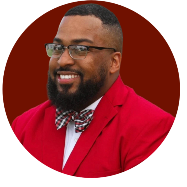 Man in red suit with glasses and bow tie smiles. Kappa Alpha Psi Western Province emblem.
