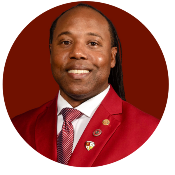 Man in red suit with dreadlocks and a tie. Western Province Kawi OMI logo in the corner.