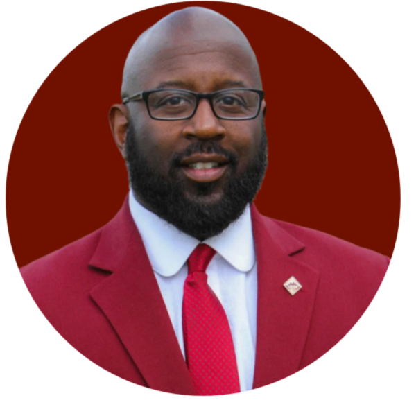 Man in red suit with glasses, smiling; Western Province Kappa Alpha Psi logo.