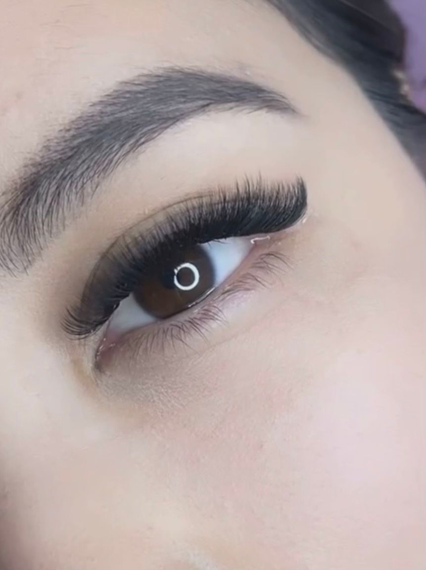 A close up of a woman 's eye with eyelashes.