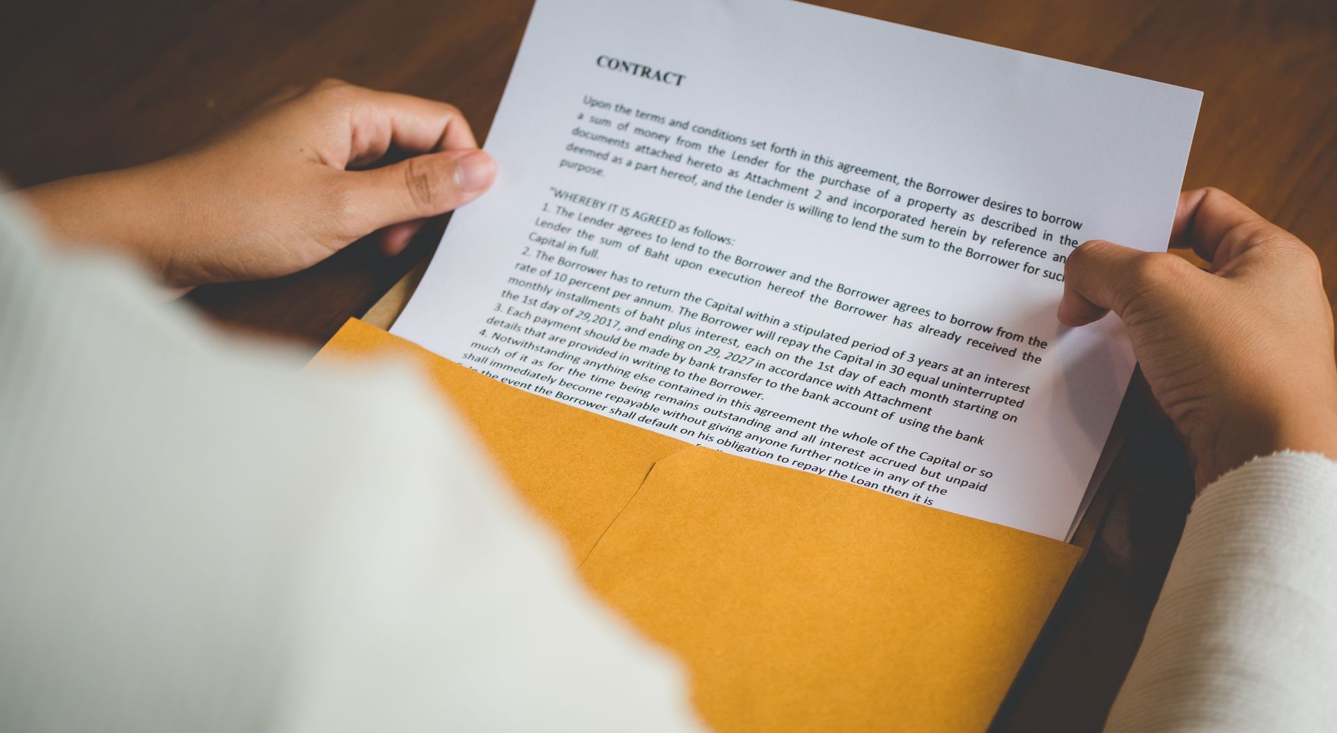 A person is holding a piece of paper in a folder.