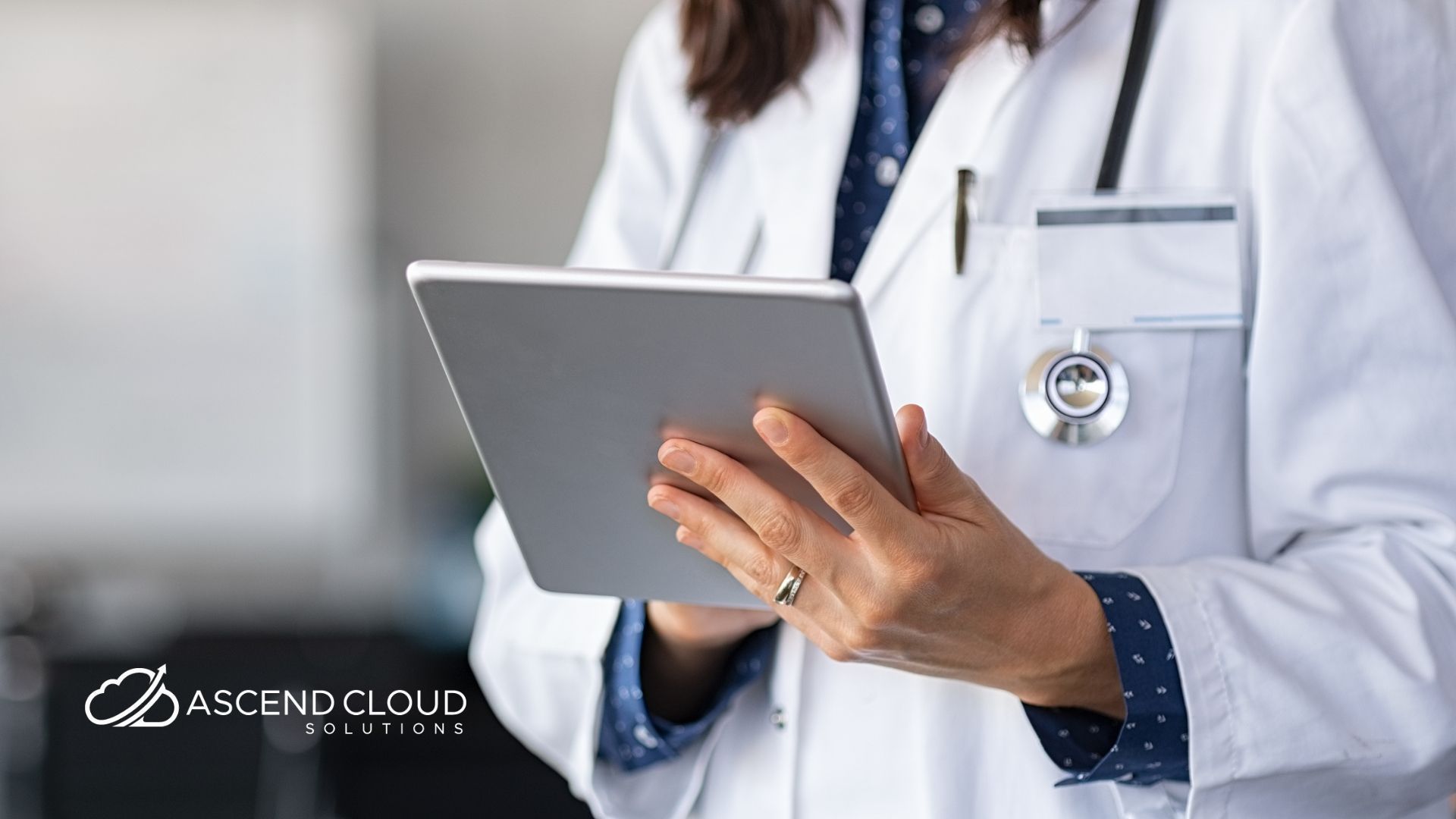 A doctor is holding a tablet in her hands.